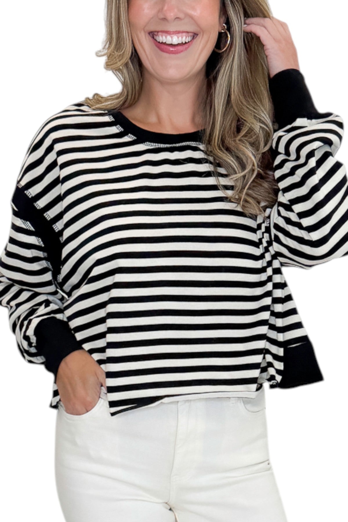 Front detail view of woman wearing Swagger Boutique’s Black &amp; White Striped Cut Out Back Sweatshirt with jeans against white studio background.