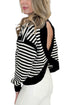 Side view of woman wearing Swagger Boutique’s Black & White Striped Cut Out Back Sweatshirt with jeans against white studio background.