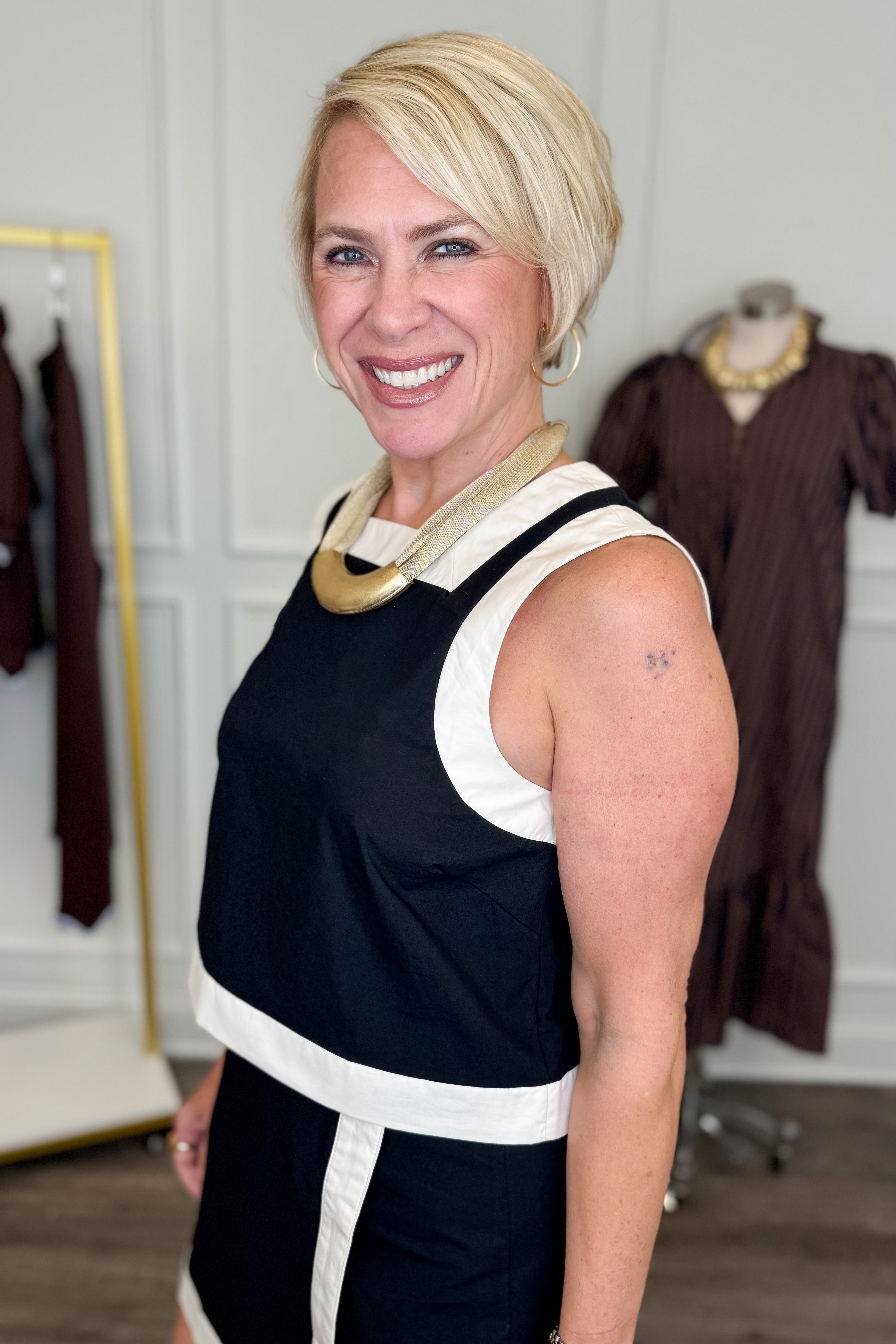 Side detail view of woman wearing Swagger Boutique’s Black &amp; White Wrap Skort &amp;  Square Neck Tank by Entro against white studio background. 