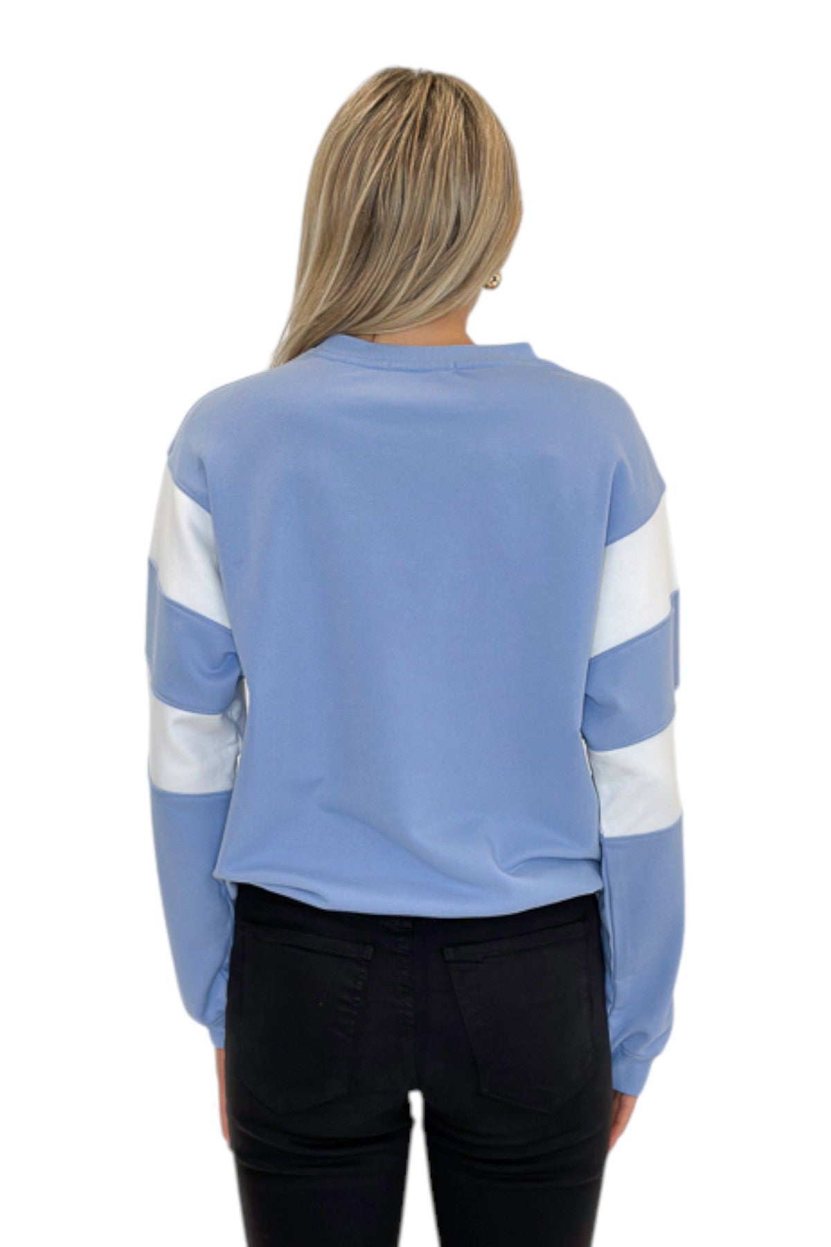 Back view of woman wearing Swagger Boutique’s Blue Color Blocked Long Sleeve Top with jeans against white studio background.