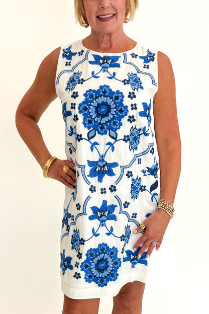 Front view of woman wearing Swagger Boutique’s Blue Embroidered Shift Dress by THML with sandals against white studio background.