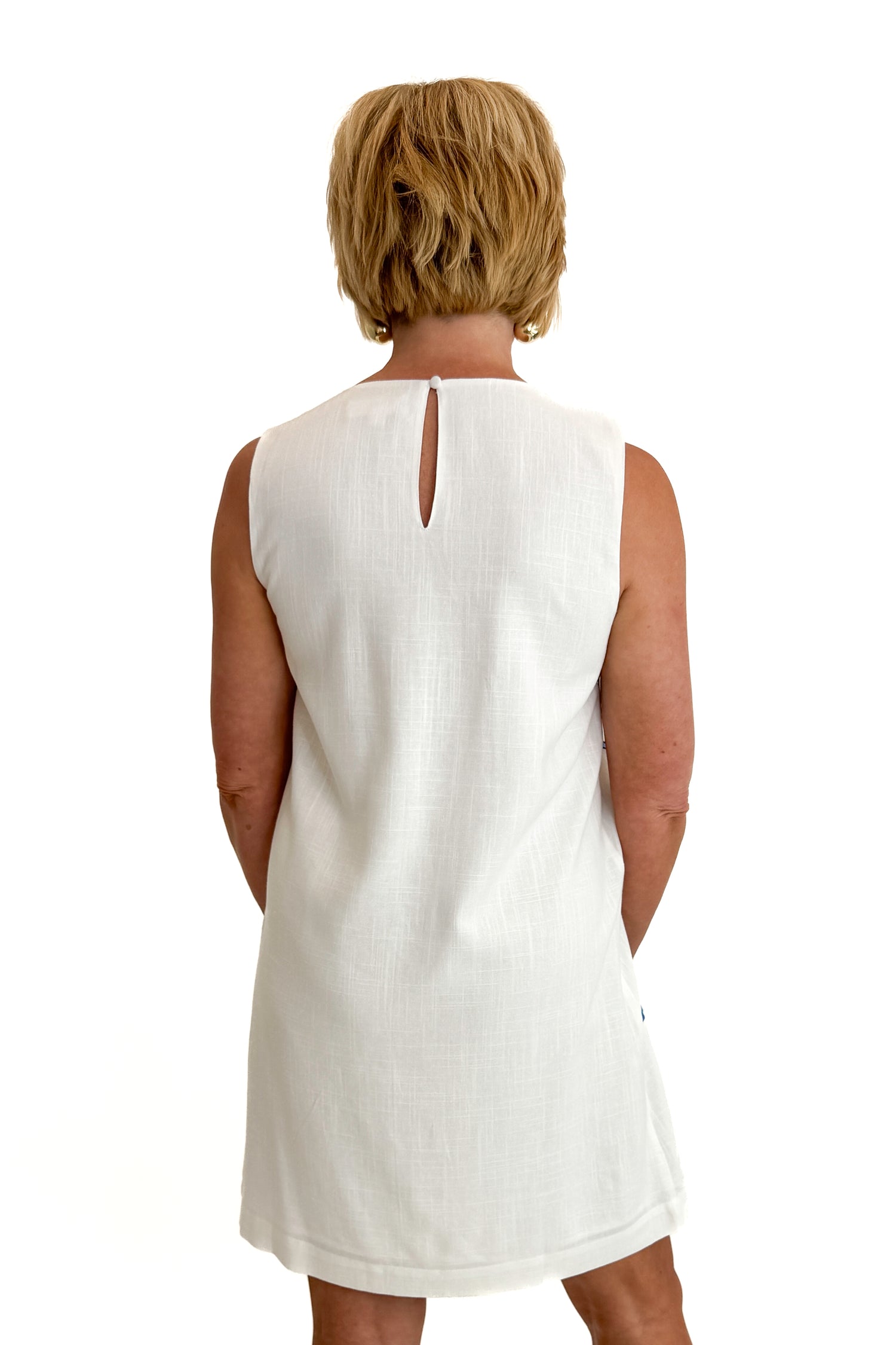 Back view of woman wearing Swagger Boutique’s Blue Embroidered Shift Dress by THML with sandals against white studio background.