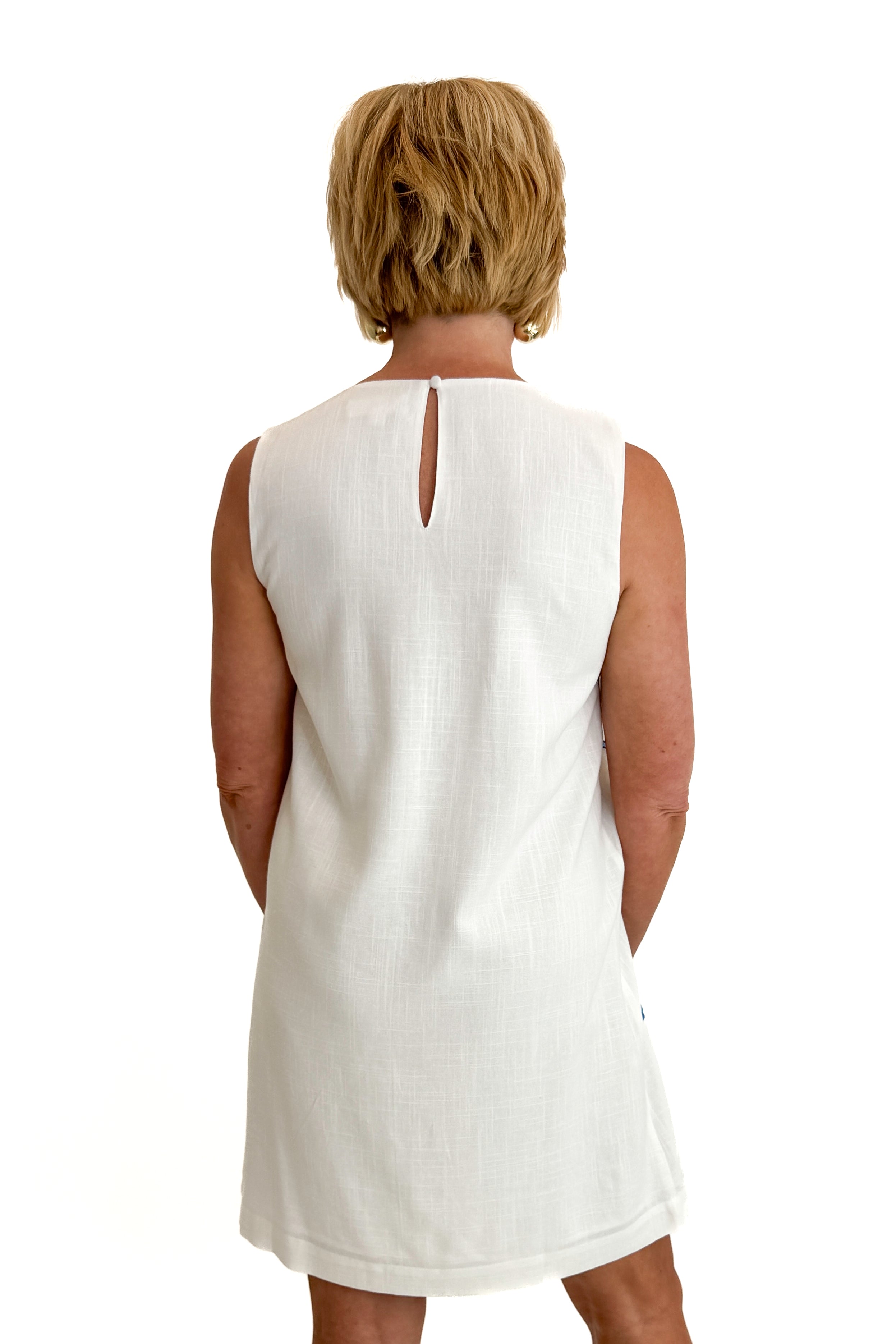 Back view of woman wearing Swagger Boutique’s Blue Embroidered Shift Dress by THML with sandals against white studio background.