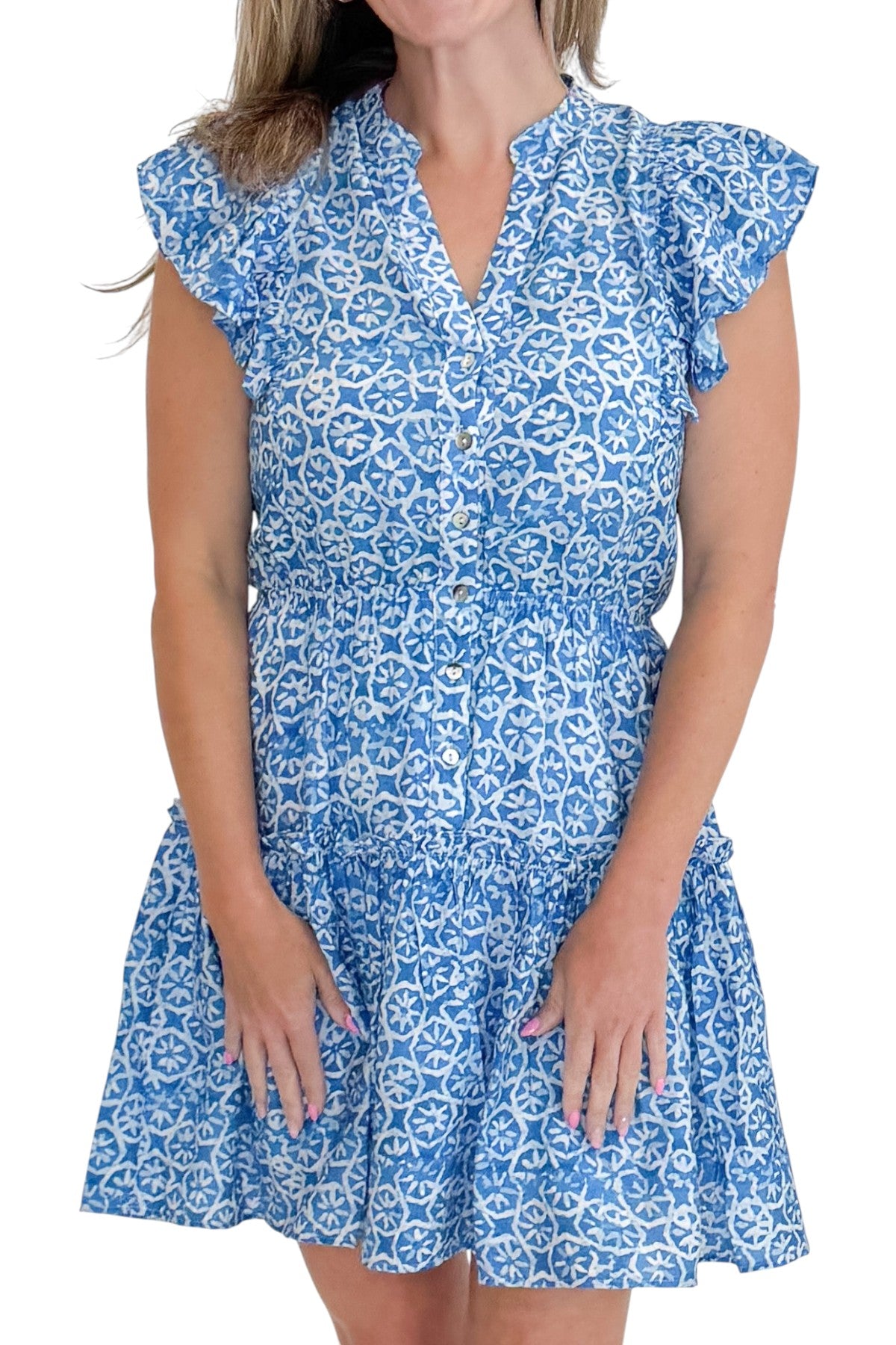 Front detail view of woman wearing Swagger Boutique’s Blue Floral Print Mini Dress with sandals against white studio background.