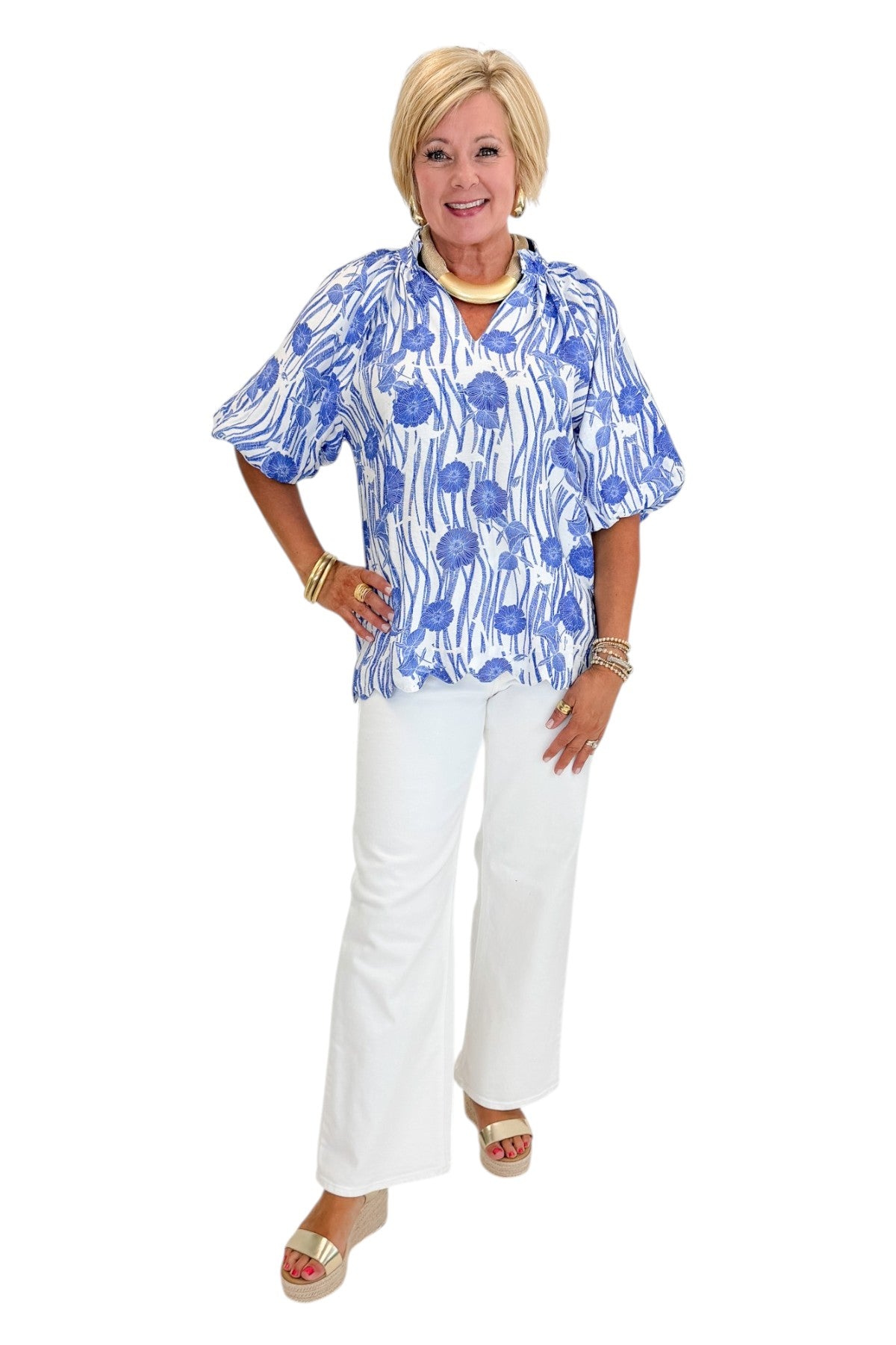 Front view of woman wearing Swagger Boutique’s Blue Floral Puff Sleeve Top with jeans against white studio background.