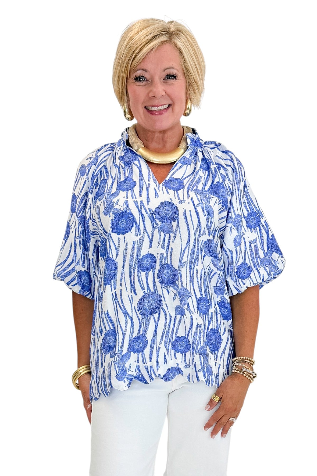 Front view of woman wearing Swagger Boutique’s Blue Floral Puff Sleeve Top with jeans against white studio background.