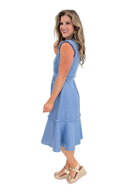 Side view of woman wearing Swagger Boutique’s Blue Fringe Sleeveless Midi Dress with sandals against white studio background.