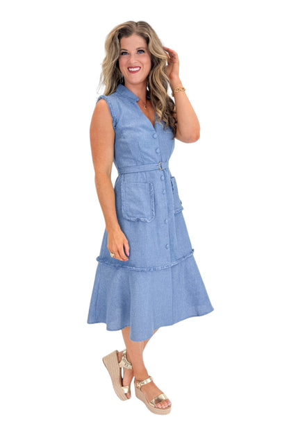 Side view of woman wearing Swagger Boutique’s Blue Fringe Sleeveless Midi Dress with sandals against white studio background.