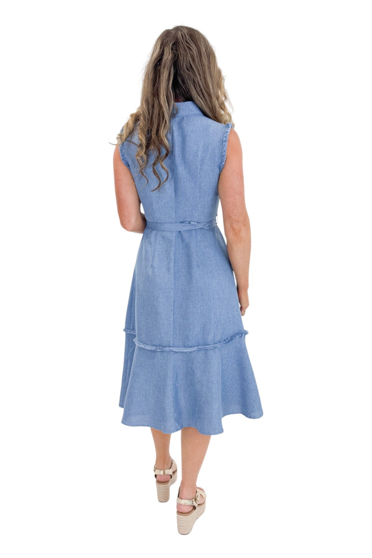 Back view of woman wearing Swagger Boutique’s Blue Fringe Sleeveless Midi Dress with sandals against white studio background.