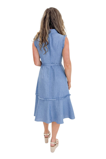 Back view of woman wearing Swagger Boutique’s Blue Fringe Sleeveless Midi Dress with sandals against white studio background.