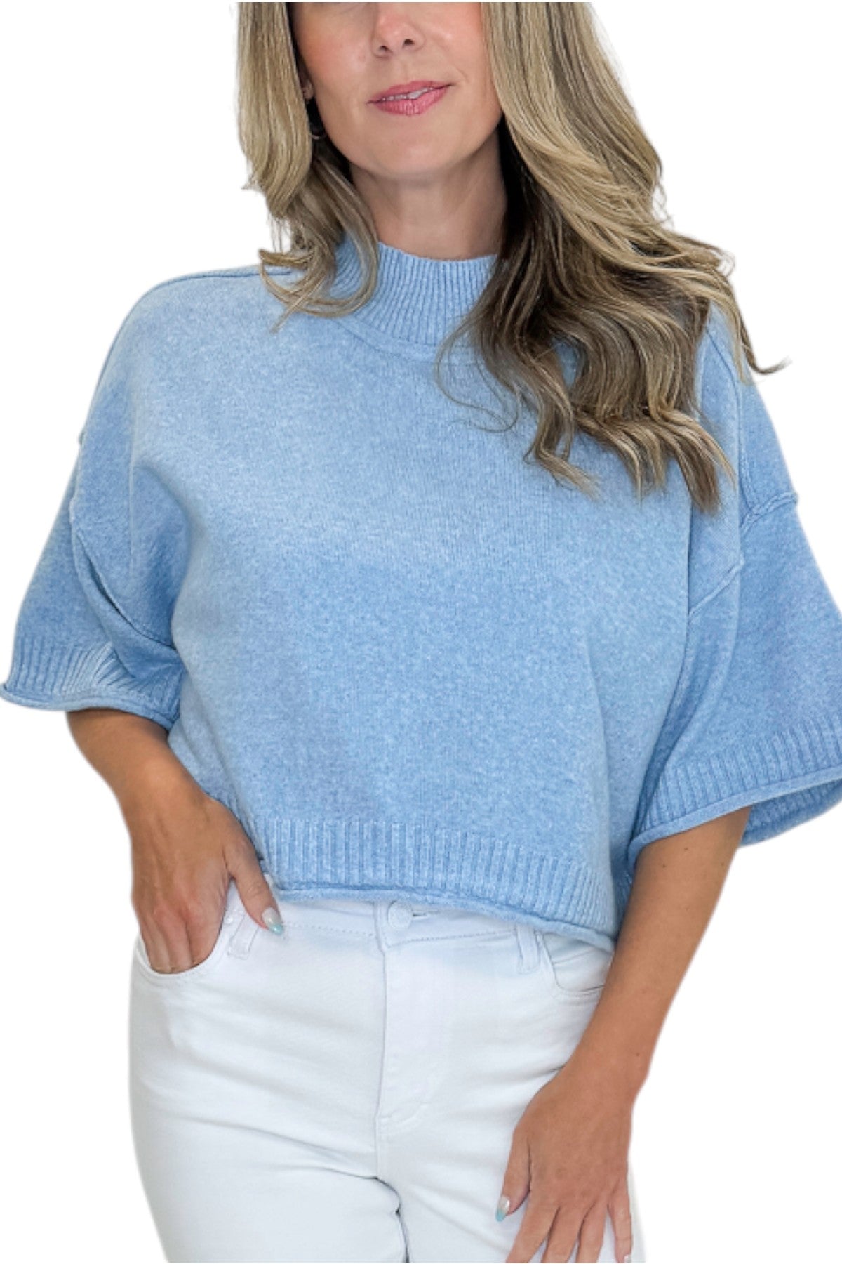 Front detail view of woman wearing Swagger Boutique’s Blue Ribbed Detail Short Sleeve Sweater with jeans against white studio background.