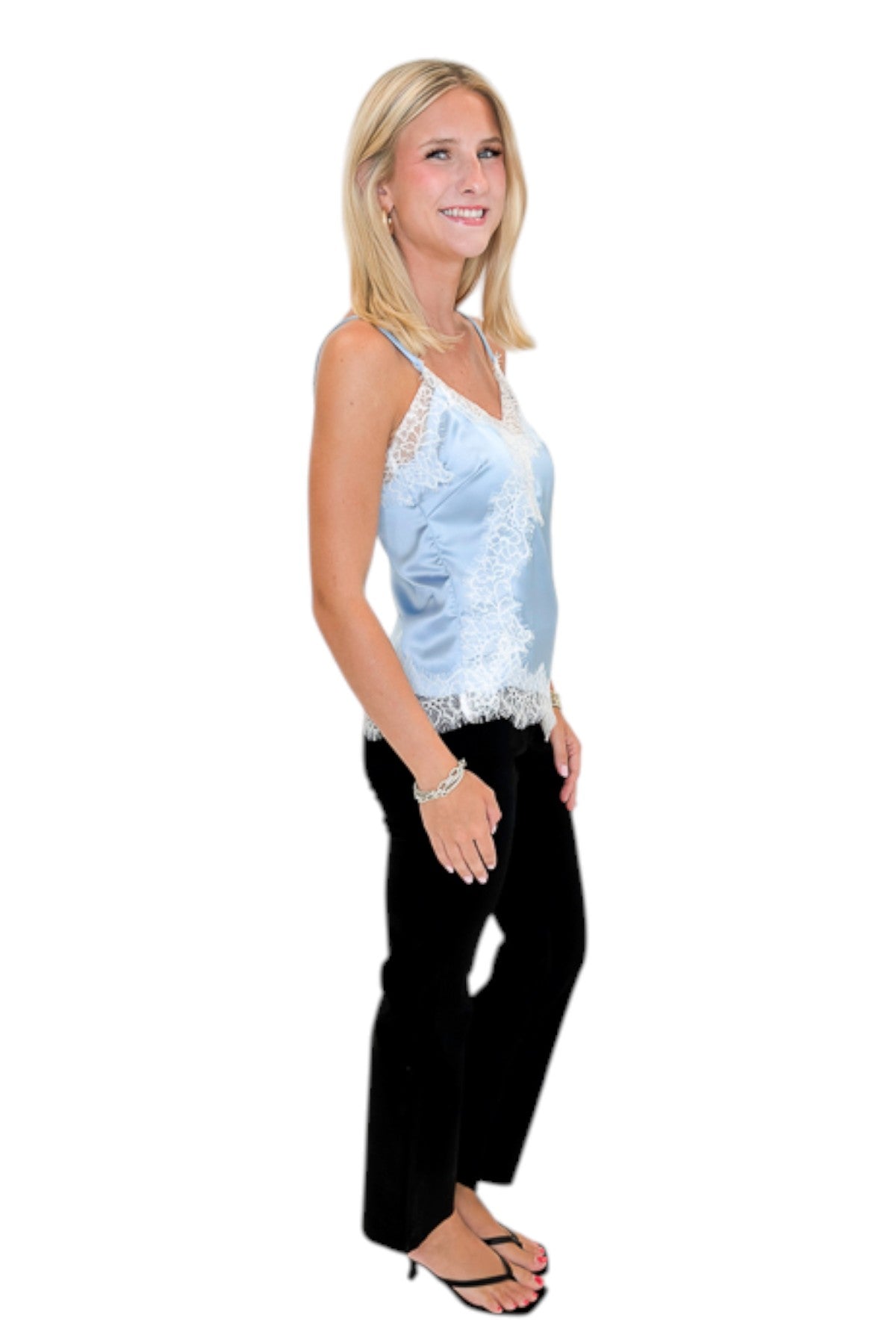 Side view of woman wearing Swagger Boutique’s Blue Satin Lace Lined Tank with jeans against white studio background.