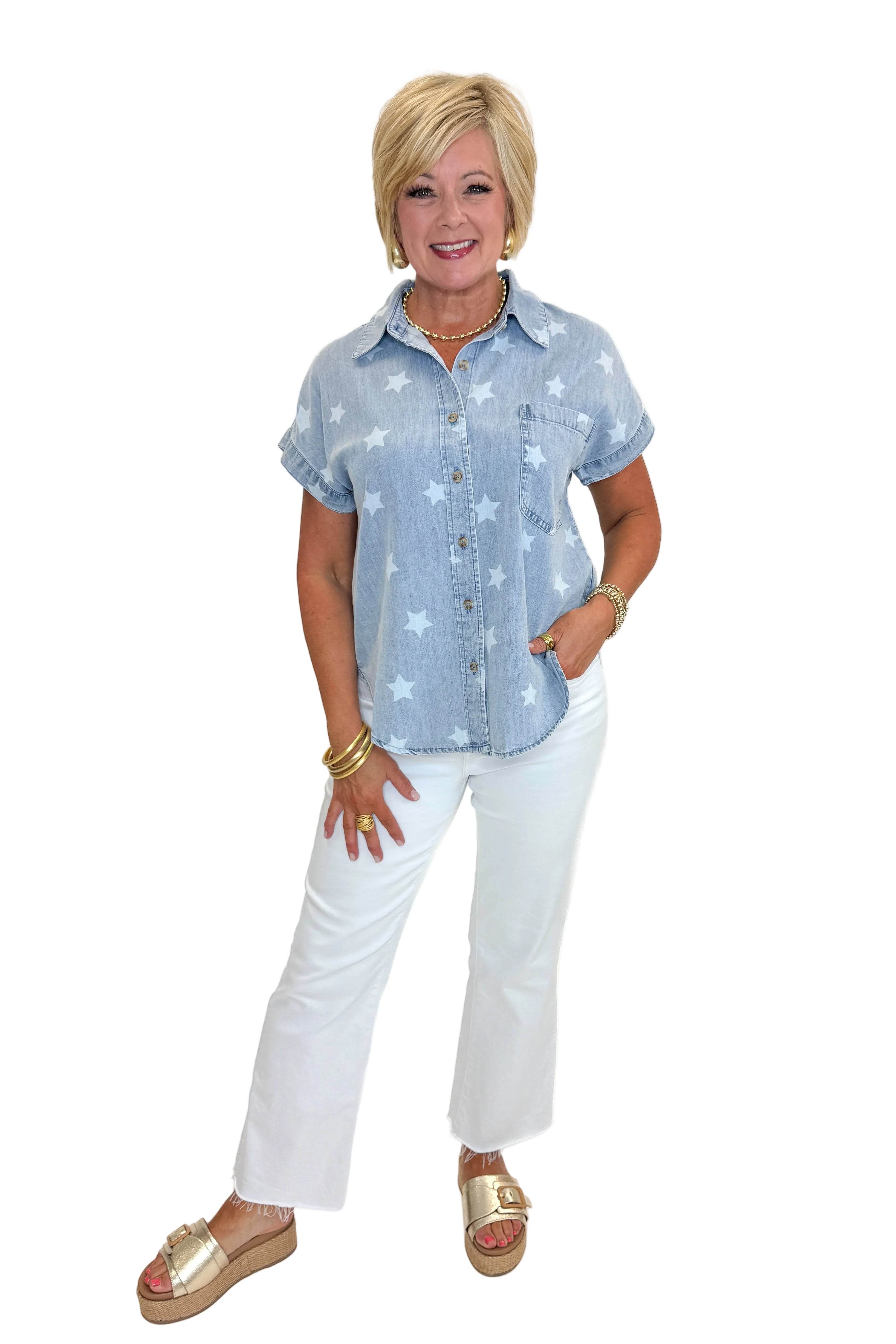 Front view of woman wearing Swagger Boutique’s Spark After Dark Blue Star Print Denim Top with jeans against white studio background.