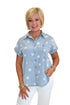Front view of woman wearing Swagger Boutique’s Spark After Dark Blue Star Print Denim Top with jeans against white studio background.
