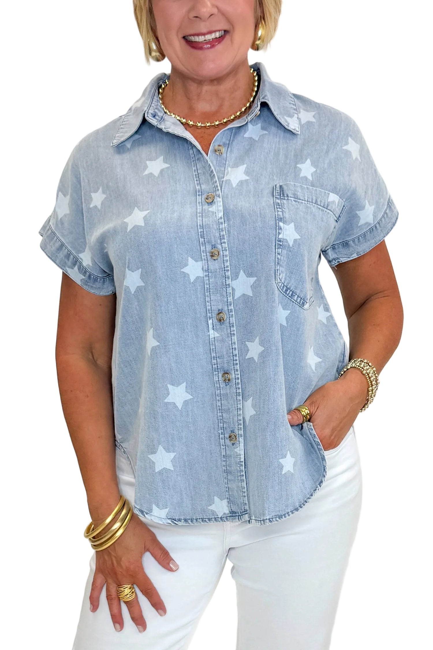 Front view of woman wearing Swagger Boutique’s Spark After Dark Blue Star Print Denim Top with jeans against white studio background.