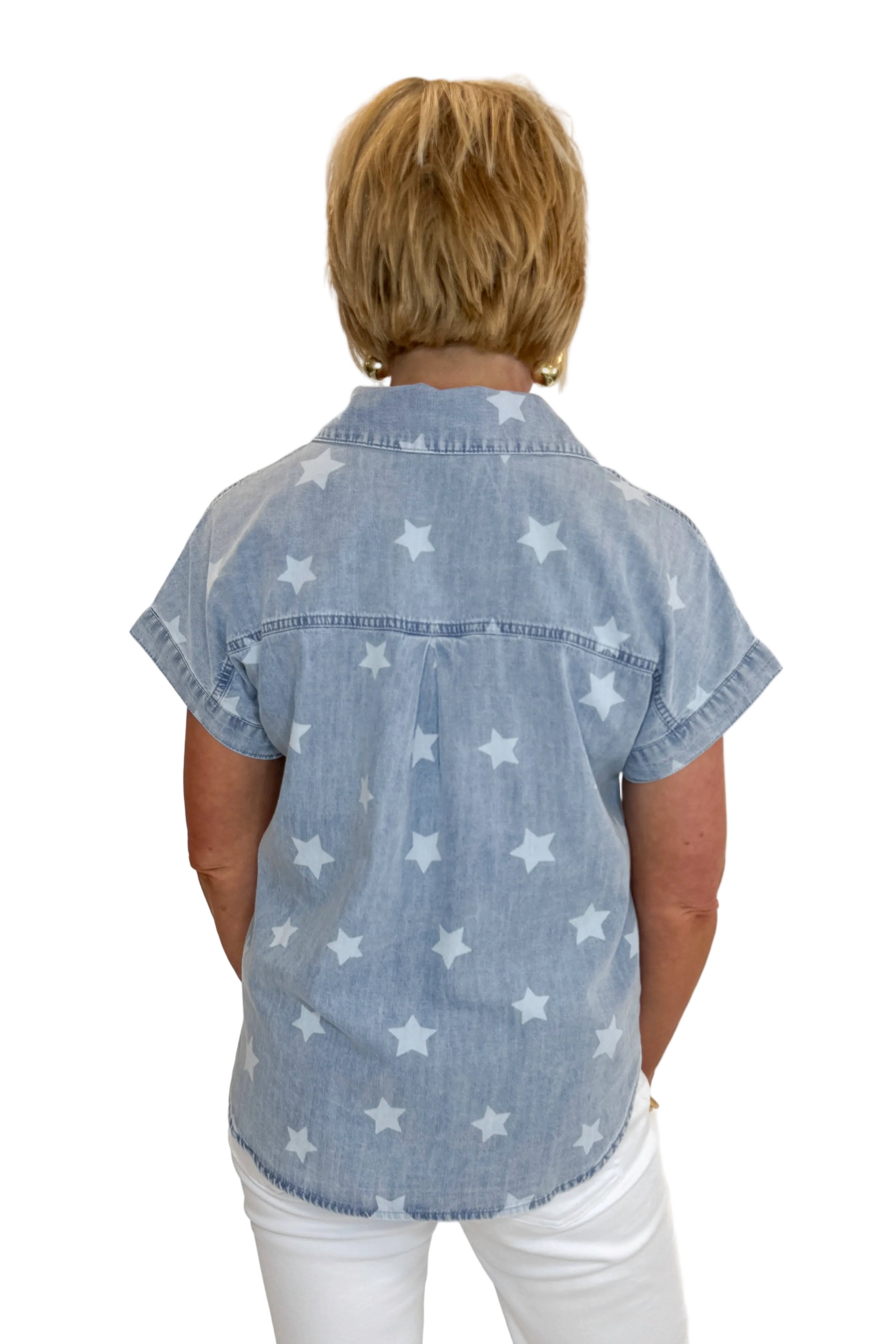 Back view of woman wearing Swagger Boutique’s Spark After Dark Blue Star Print Denim Top with jeans against white studio background.