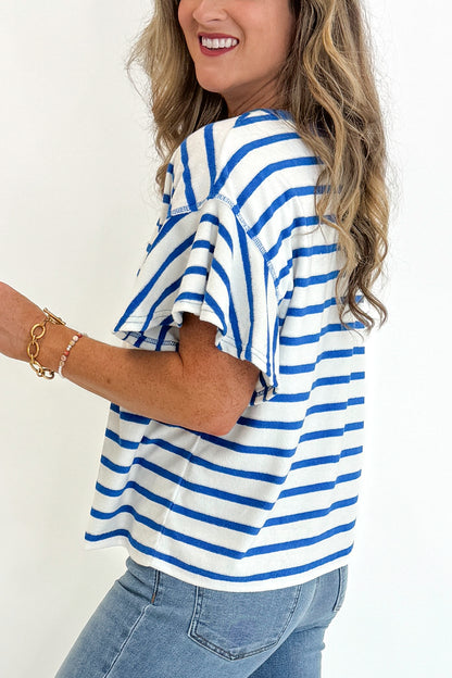 Side detail view of woman wearing Swagger Boutique’s Striped Flutter Sleeve Terry Top with jeans against white studio background.