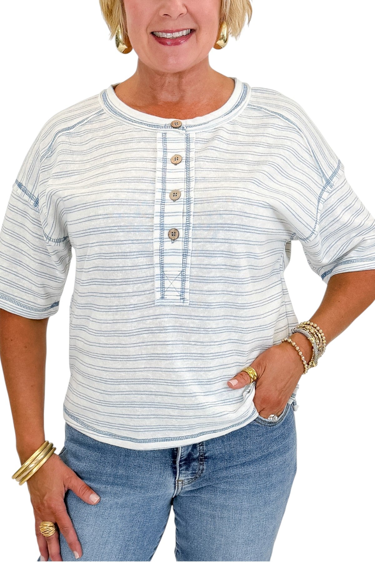 Front detail view of woman wearing Swagger Boutique’s Blue Striped Relaxed Fit Top with jeans against white studio background.