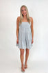 Front view of woman wearing Swagger Boutique’s Blue Striped Sleeveless Tiered Mini Dress with sandals against white studio background.