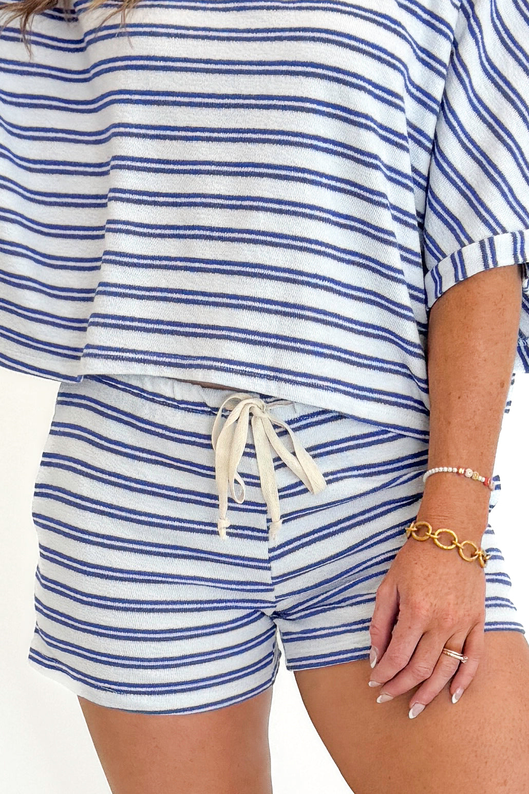 Front view of woman wearing Swagger Boutique’s Blue Striped Terry Cloth Shorts with matching Blue Striped Terry Cloth Top against white studio background.