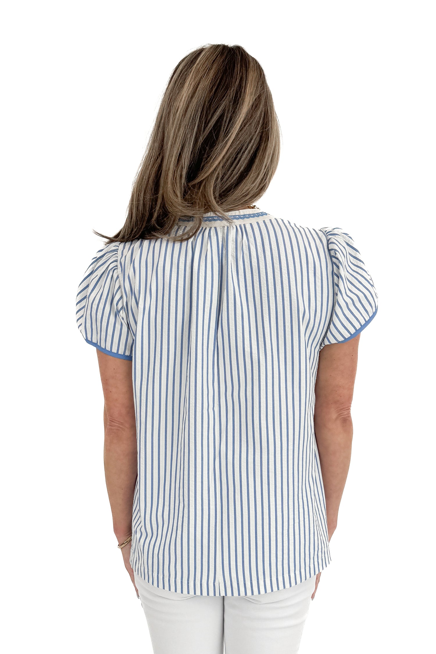 Back view of woman wearing Blue Striped &amp; Embroidered Flutter Sleeve Top with jeans against white studio background.