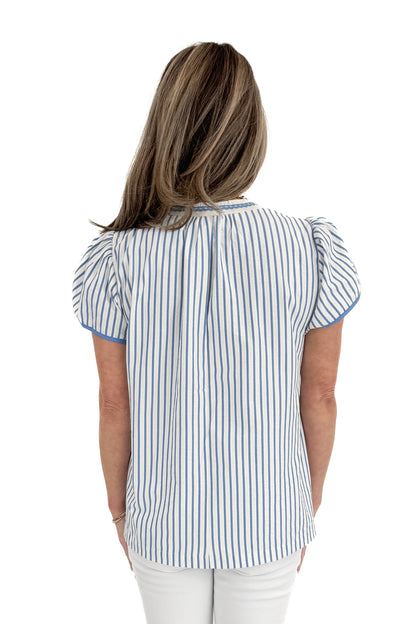Back view of woman wearing Blue Striped &amp; Embroidered Flutter Sleeve Top with jeans against white studio background.