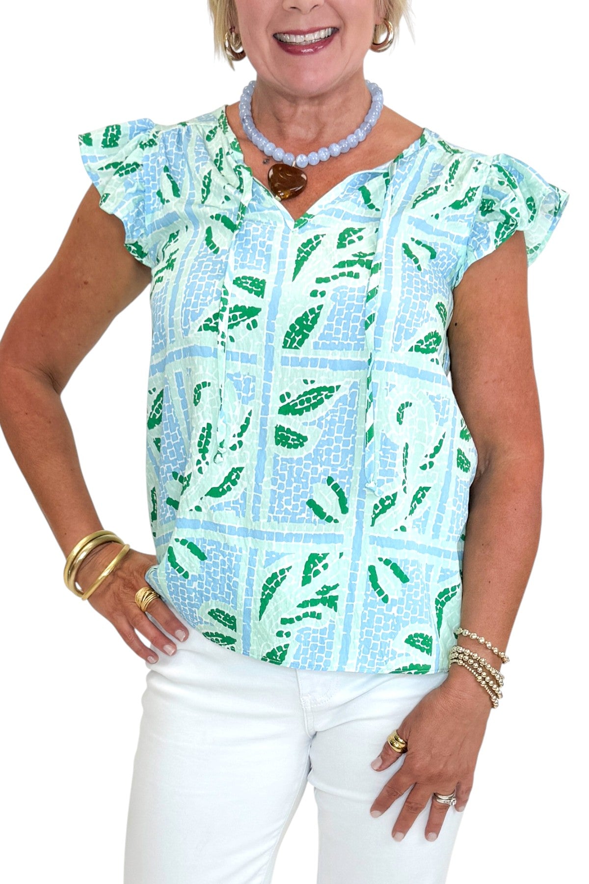 Front detail view of woman wearing Swagger Boutique’s Blue Tile Print Lydia Top by Mary Square with jeans against white studio background.