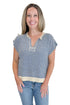 Front view of woman wearing Swagger Boutique’s Blue & Beige Striped Sleeveless Sweater with jeans against white studio background.