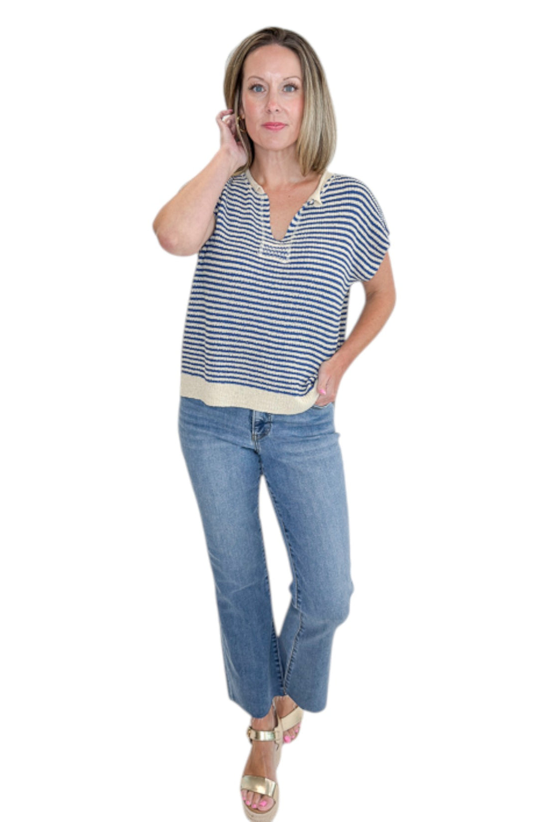 Front view of woman wearing Swagger Boutique’s Blue &amp; Beige Striped Sleeveless Sweater with jeans against white studio background.