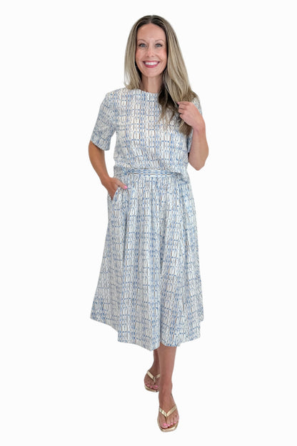 Front view of woman wearing Swagger Boutique’s Blue &amp; Brown Abstract Print Short Sleeve Top with matching skirt against white studio background.