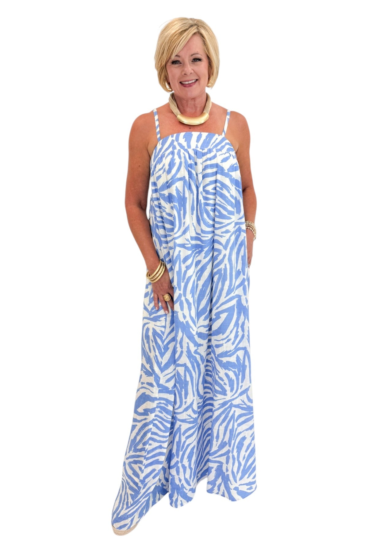 Front view of woman wearing Swagger Boutique’s Blue &amp; Cream Animal Print Maxi Dress by Entro with sandals against white studio background.