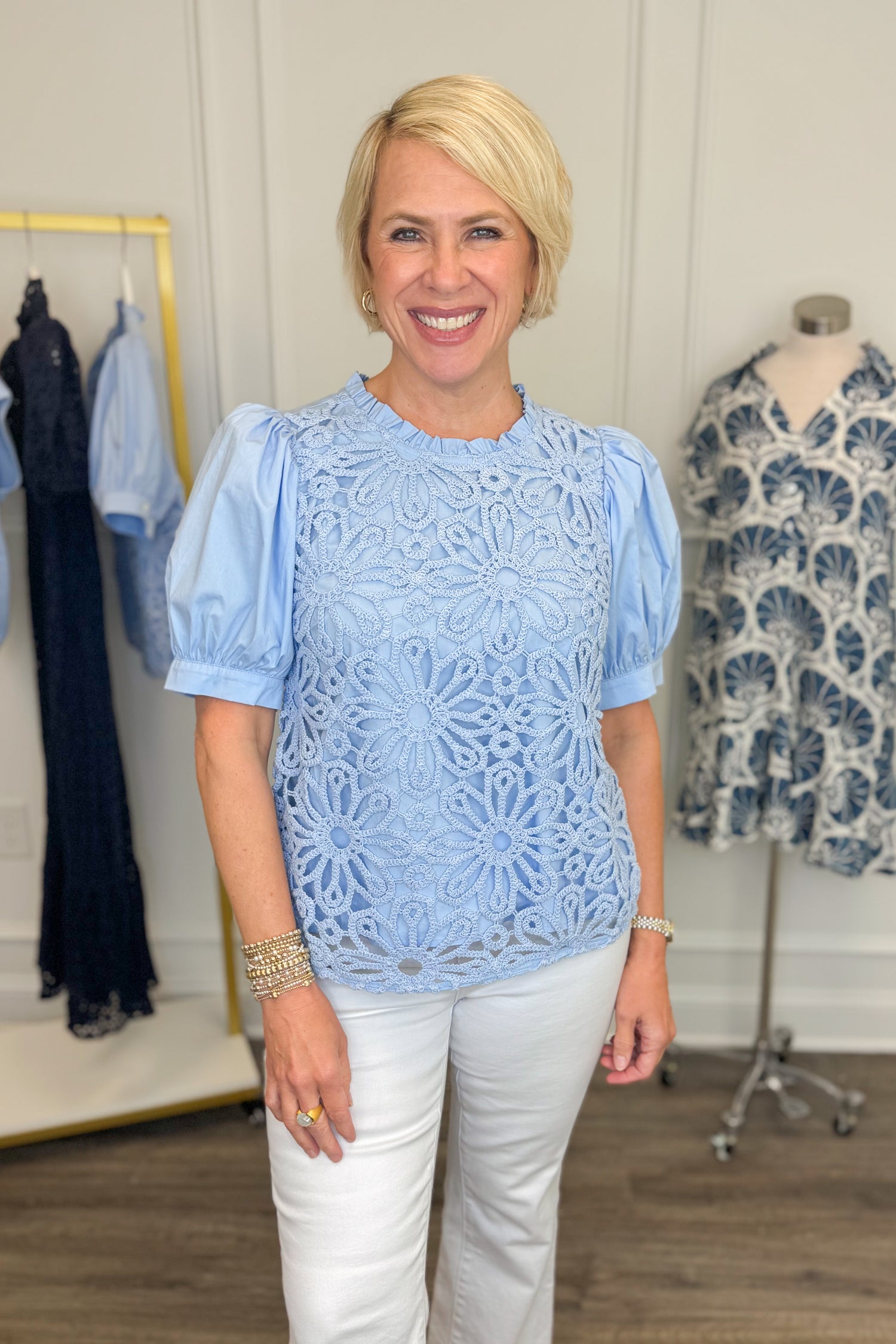 Front view of woman wearing Swagger Boutique’s Blue Crochet Puff Sleeve Top with jeans against white studio background.