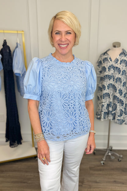 Front view of woman wearing Swagger Boutique’s Blue Crochet Puff Sleeve Top with jeans against white studio background.