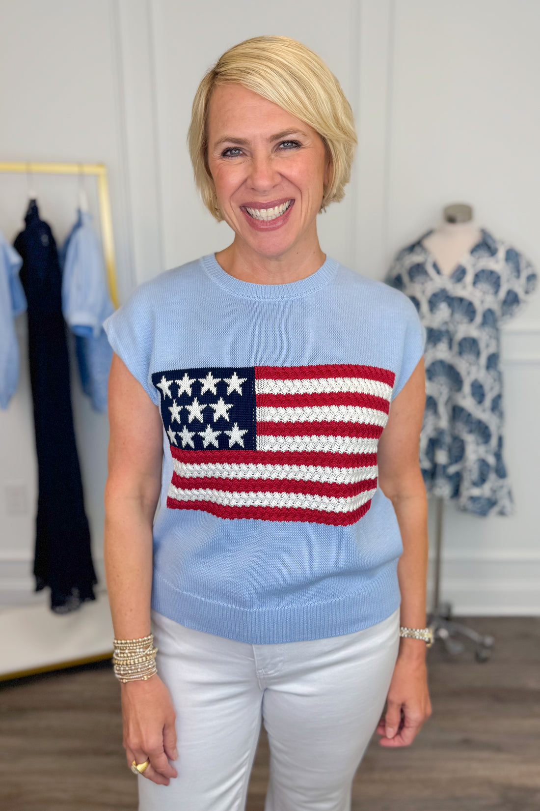 Front view of woman wearing Swagger Boutique’s Blue Flag Cap Sleeve Sweater with jeans against white studio background.