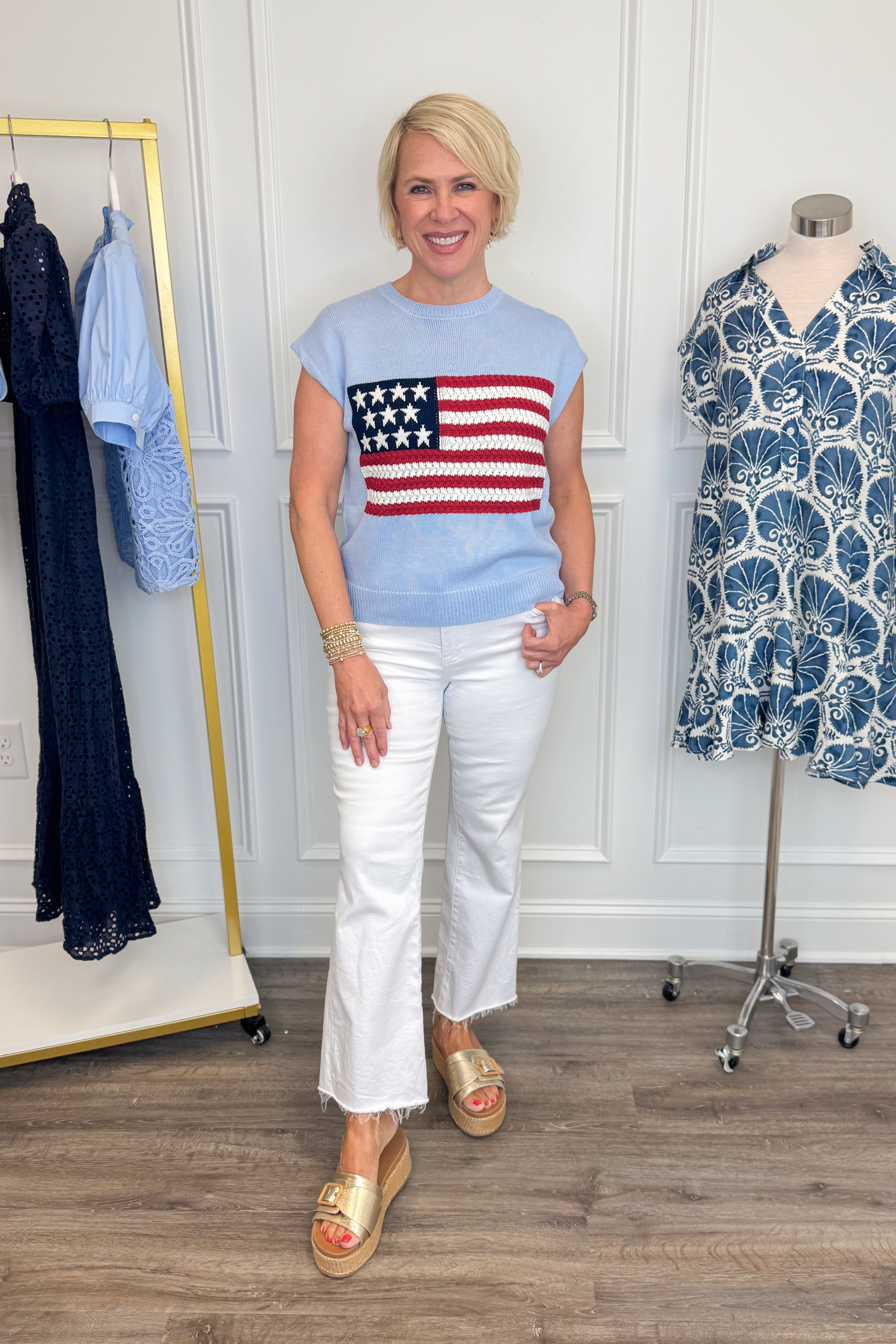 Front view of woman wearing Swagger Boutique’s Blue Flag Cap Sleeve Sweater with jeans against white studio background.