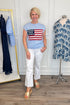Front view of woman wearing Swagger Boutique’s Blue Flag Cap Sleeve Sweater with jeans against white studio background.