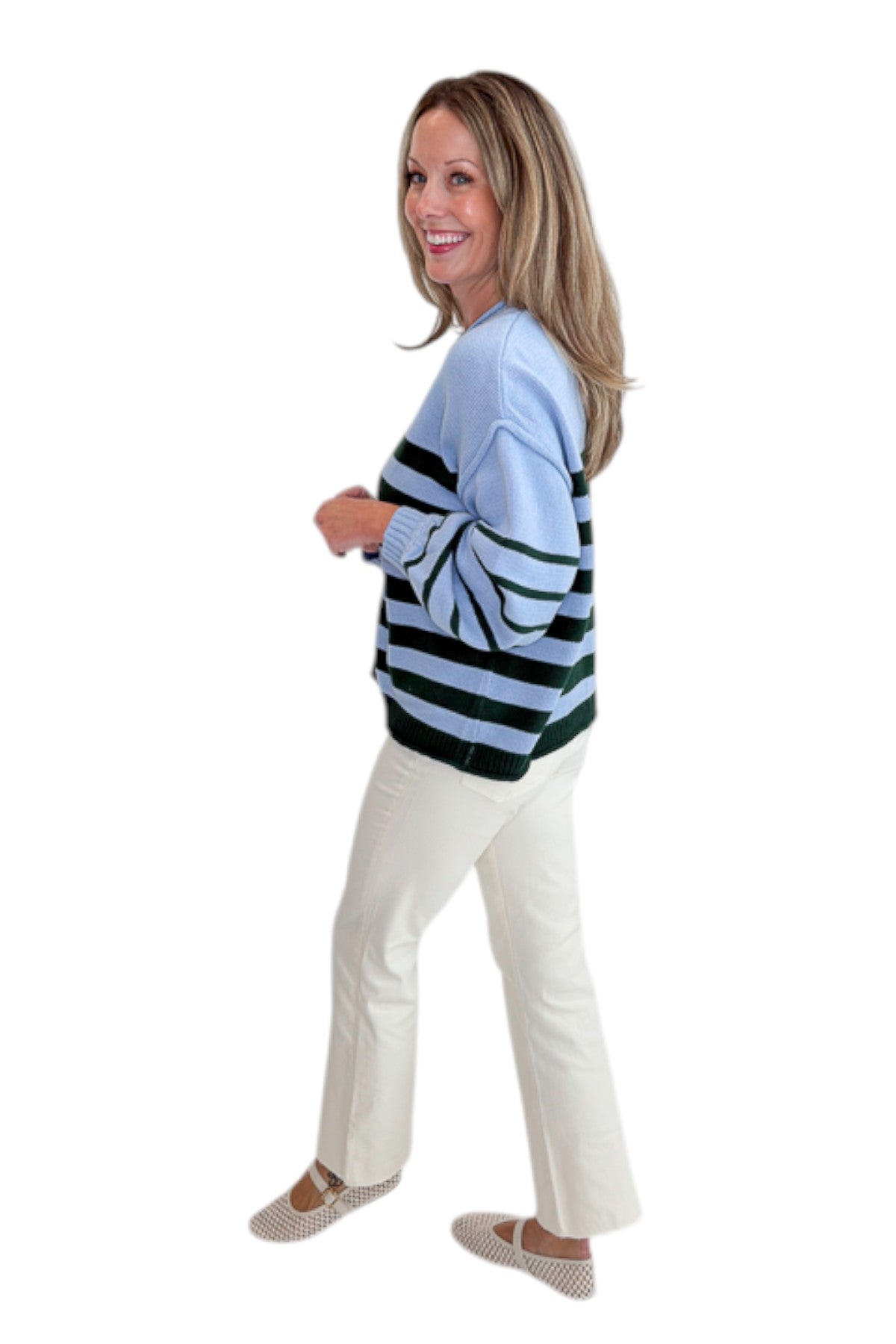 Side view of woman wearing Swagger Boutique’s Blue &amp; Green Striped Sweater with jeans against white studio background.