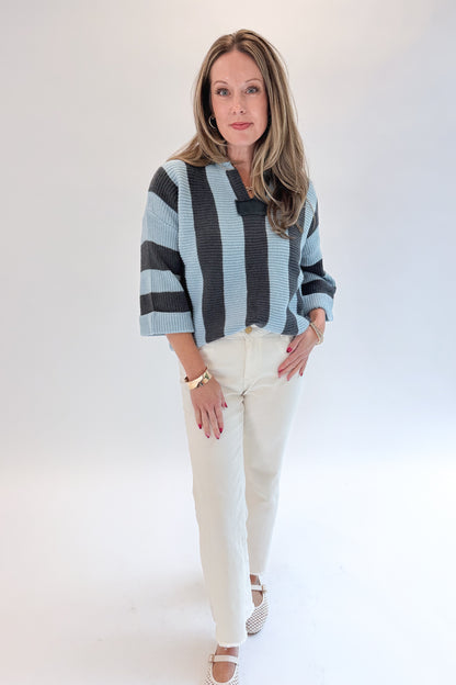 Front view of woman wearing Swagger Boutique’s Blue &amp; Grey Striped 3/4 Sleeve Sweater with jeans against white studio background.