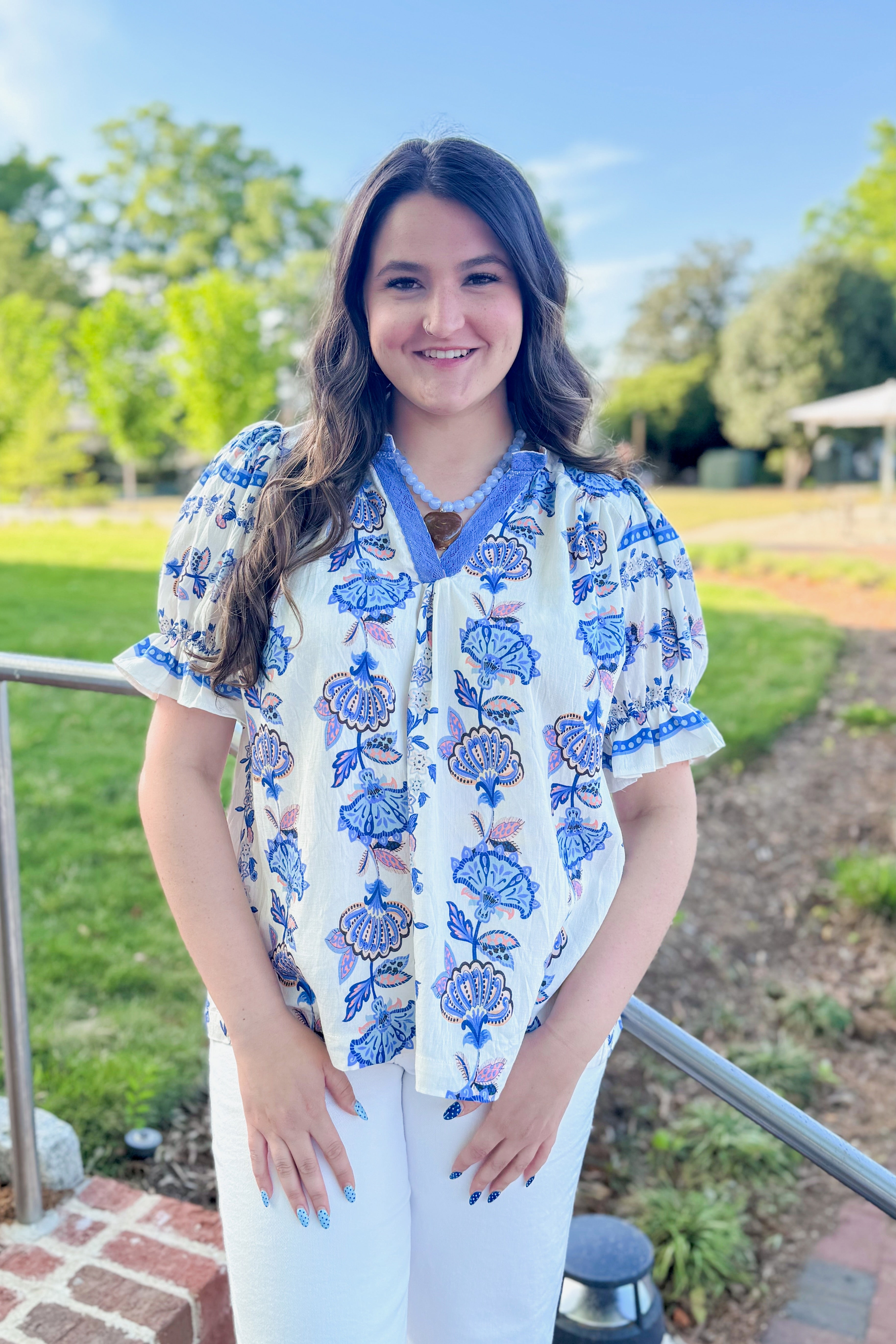 Front view of woman wearing Blue &amp; Multi Printed Lace Detail Top with jeans outside at a park.