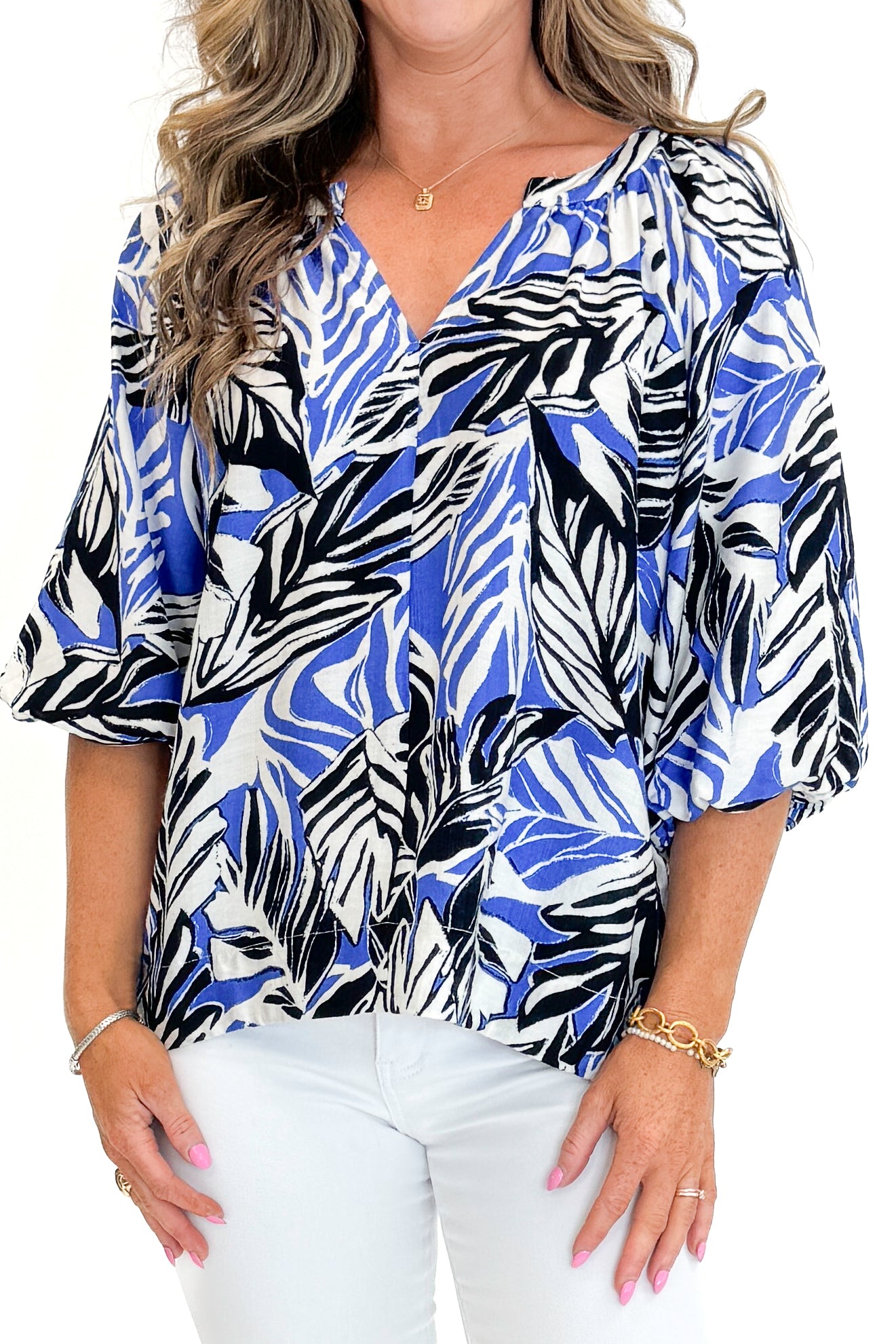 Front detail view of woman wearing Swagger Boutique’s Blue &amp; Navy Tropical Printed 3/4 Sleeve Top with jeans against white studio background.