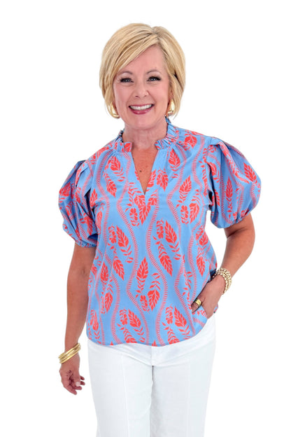 Front view of woman wearing Swagger Boutique’s Blue &amp; Orange Botanical Print Short Sleeve Top with jeans against white studio background.