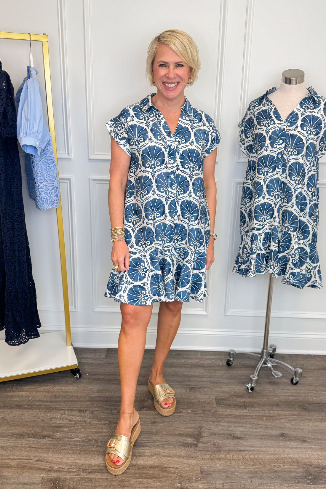 Front view of woman wearing Swagger Boutique’s Blue Printed Short Sleeve Dress with sandals against white studio background.