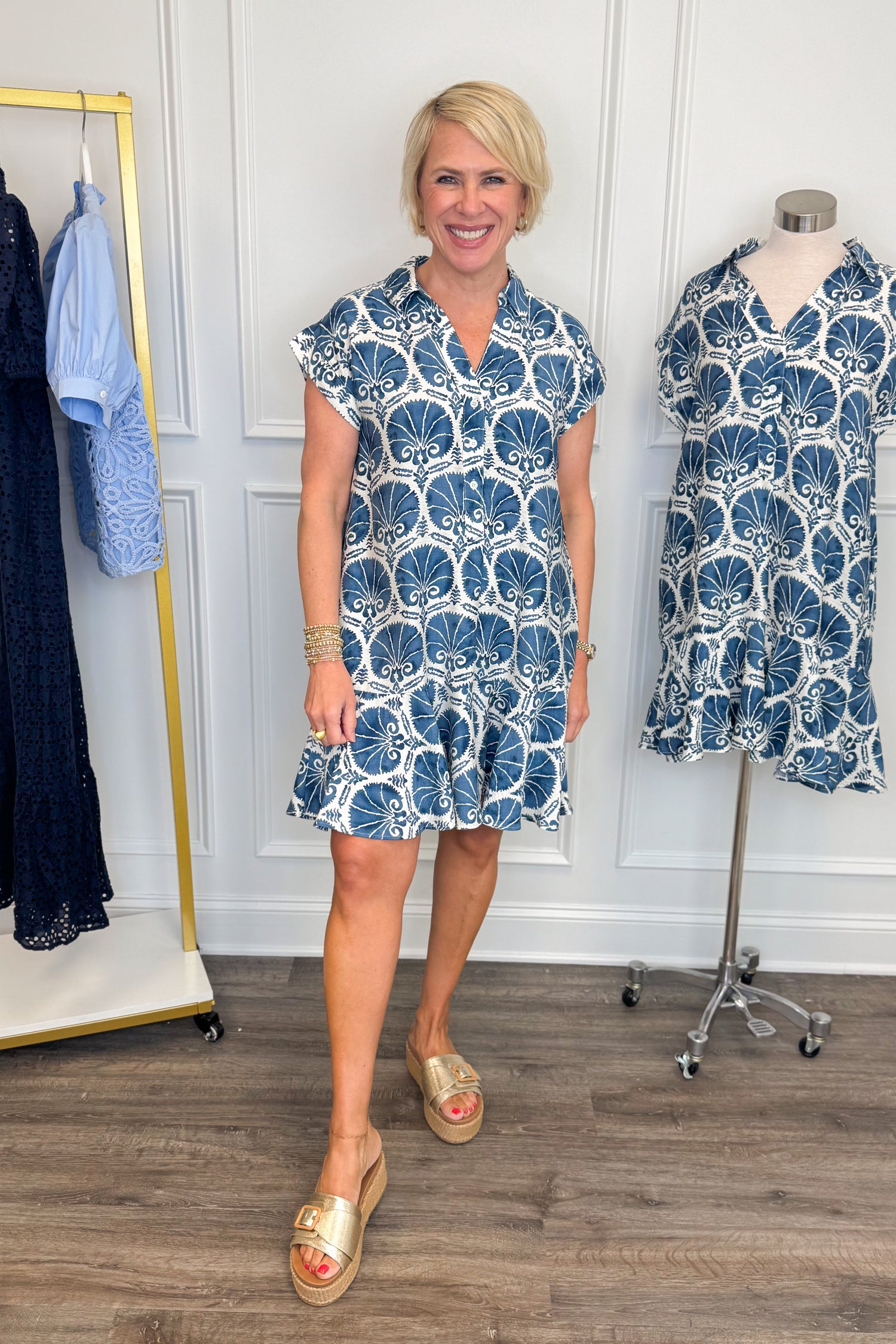 Front view of woman wearing Swagger Boutique’s Blue Printed Short Sleeve Dress with sandals against white studio background.