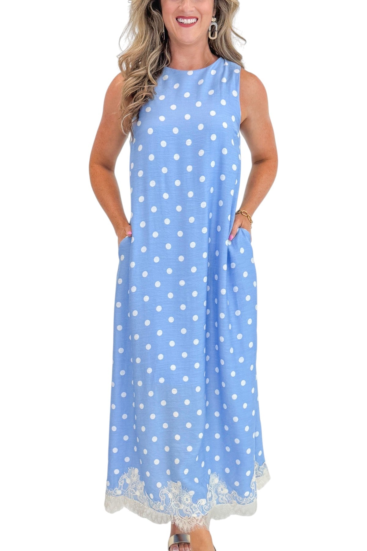 Front detail view of woman wearing Swagger Boutique’s Blue &amp; White Polka Dot Lace Trim Maxi Dress by Entro with wedges against white studio background.