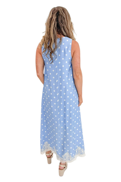 Back view of woman wearing Swagger Boutique’s Blue &amp; White Polka Dot Lace Trim Maxi Dress by Entro with wedges against white studio background.