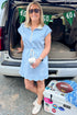 Front view of woman wearing Swagger Boutique’s Blue With White Lining Scallop Hem 1/4 Zip Dress with sneakers at a football tailgate. 