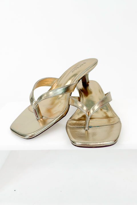 Brat- Gold Thong Kitten Heels against white studio background.