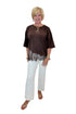 Front view of woman wearing Swagger Boutique’s Brown Asymmetrical Lace Hem Top by Entro with jeans against white studio background.