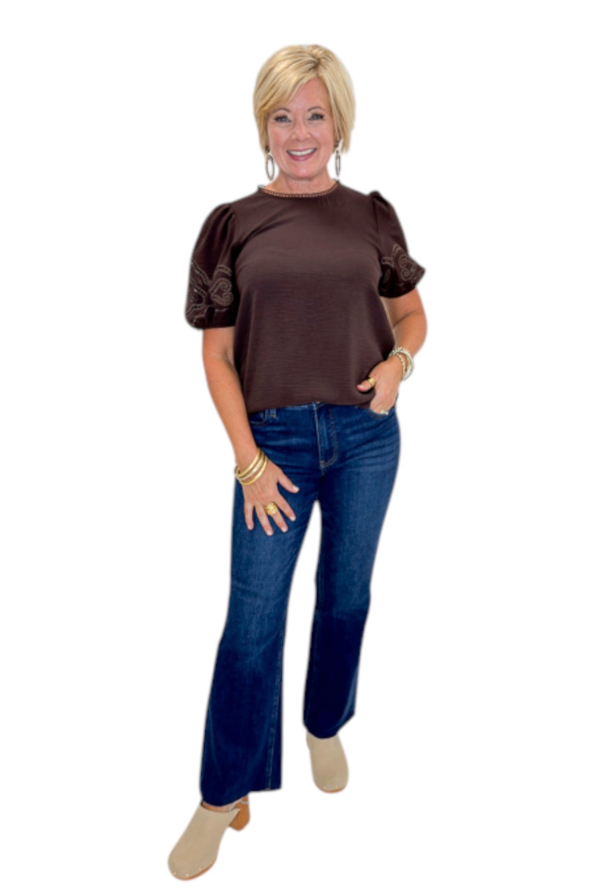Front view of woman wearing Swagger Boutique’s Brown Embroidered Short Sleeve Top with jeans against white studio background.