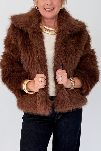 Front detail view of woman wearing Swagger Boutique’s Brown Faux Fur Jacket with jeans against white studio background.